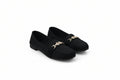 A pair of black slip-on flats with a gold-tone decorative chain link detail across the vamp, displayed on a light gray studio background.