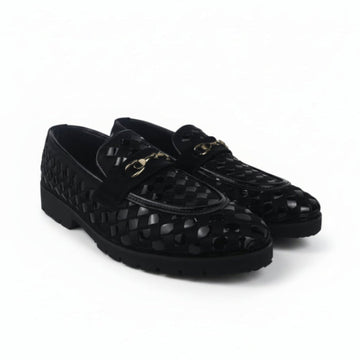 A pair of black woven leather loafers with a gold-tone horsebit detail on the strap, displayed against a light gray fabric backdrop.