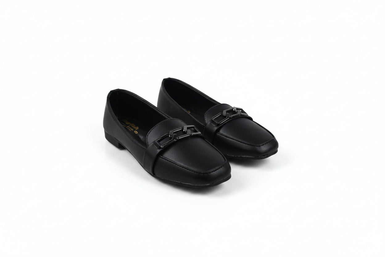 A pair of black leather loafers with a decorative metal buckle strap across the vamp, displayed on a light gray studio background.
