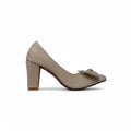 A single beige high-heeled pump with a block heel and a small metallic bow detail on the toe, shown against a light gray textured background.