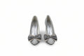 A pair of women's pointed-toe high heels in a light champagne or off-white color, featuring a wide gray satin bow with a rhinestone-embellished center on the vamp.