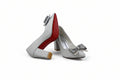 A pair of women's high-heeled pumps in a light silver-gray textured fabric, featuring a pointed toe, a decorative gray bow on the side, and a signature red outsole, displayed against a white studio backdrop.