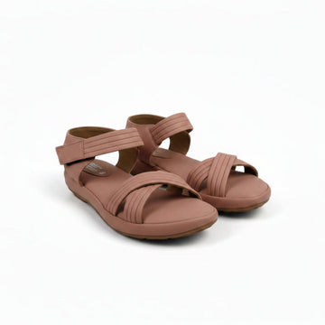 A pair of women's flat sandals in a dusty rose or mauve color, featuring criss-cross front straps and an adjustable ankle strap, shown on a light gray fabric background.
