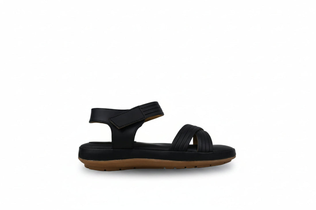 A pair of women's flat sandals in a dusty rose or mauve color, featuring criss-cross front straps and an adjustable ankle strap, shown on a light gray fabric background.