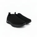 A pair of black slip-on knit sneakers with textured soles, displayed on a light gray background.