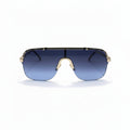 A pair of shield-style sunglasses with a gold metal frame and blue gradient lenses, displayed on a white surface with silver studio reflectors in the background.