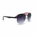 Ray-Ban Aviator sunglasses with a black acetate frame, gold metal rims, gradient purple lenses, and red temple tips, displayed on a white surface between two gray softbox lights.