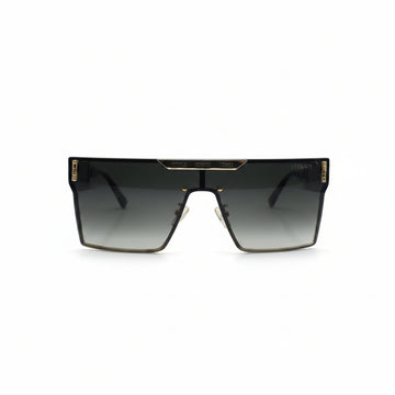 A pair of square shield sunglasses with a dark gray gradient lens and gold metal trim, displayed on a white surface with a reflective silver backdrop.