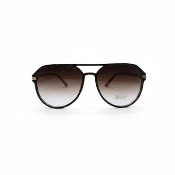 Dior aviator sunglasses with dark brown gradient lenses and gold metal frames, displayed on a white surface between two silver textured panels.
