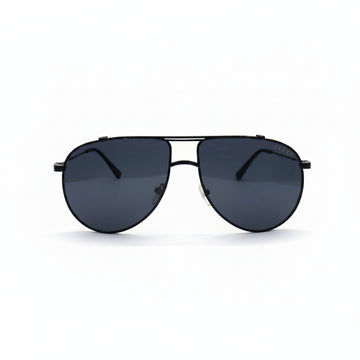 A pair of classic aviator sunglasses with a thin black metal frame and dark gray lenses, displayed on a white surface with two silver studio reflectors in the background.