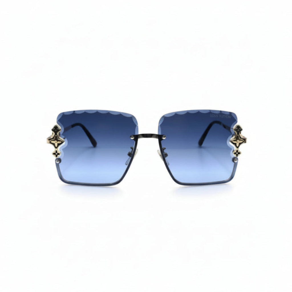 Square sunglasses with blue gradient lenses and ornate gold-toned metal accents on the sides, displayed against a white background with reflective silver panels on either side.