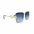 Louis Vuitton square sunglasses with blue gradient lenses, gold metal frames, and the iconic LV monogram on the bridge, displayed on a white surface with textured gray props on either side.