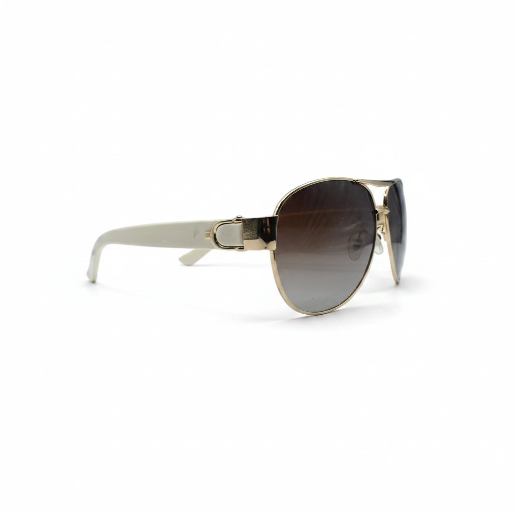A pair of classic aviator sunglasses with a gold metal frame and brown gradient lenses, displayed on a white surface with a gray textured backdrop on either side.