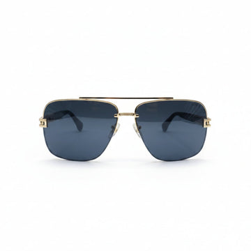 A pair of aviator-style sunglasses with a gold metal frame and dark gray lenses, displayed on a white surface between two textured silver panels.
