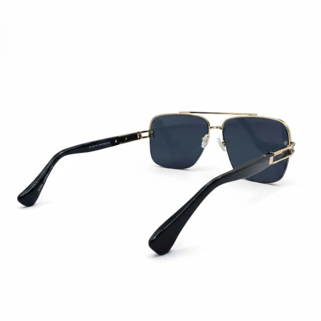 A pair of aviator-style sunglasses with dark blue lenses, a gold metal frame, and black temples, displayed on a white surface with a silver studio backdrop.