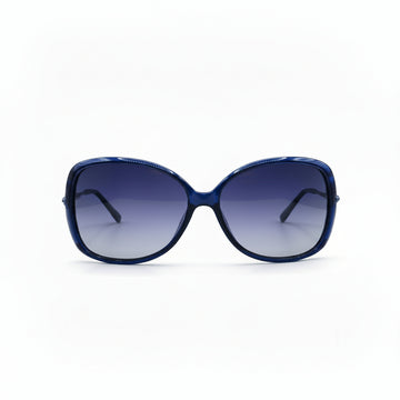 Oversized cat-eye sunglasses with a dark blue acetate frame and gradient purple lenses, displayed on a white surface between two silver studio reflectors.