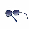 Blue cat-eye sunglasses with gradient purple-blue lenses, displayed on a white surface between two silver studio reflectors.