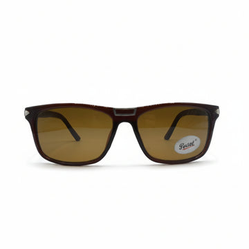A pair of square sunglasses with a dark brown acetate frame and amber-brown tinted lenses, displayed on a white surface with a silver reflective case behind them. A small 'Polo' brand sticker is visible on the lower right lens.