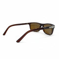 A pair of vintage-style sunglasses with dark brown acetate frames and brown tinted lenses, displayed on a white surface between two silver studio reflectors.