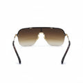 A pair of square shield-style sunglasses with a brown gradient lens, gold metal frame, and tortoiseshell temples, displayed on a white surface with silver studio reflectors in the background.