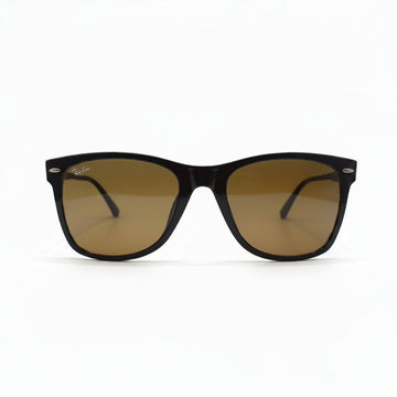 A pair of classic Wayfarer-style sunglasses with a dark brown acetate frame and warm brown-tinted lenses, displayed on a white surface with a reflective silver backdrop.