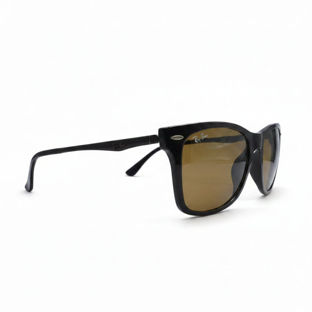 A pair of Ray-Ban sunglasses with a black acetate frame and brown-tinted lenses, displayed on a white surface with a gray textured background.