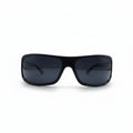 Black wrap-around sunglasses with dark lenses, displayed on a white surface with two textured silver panels in the background.