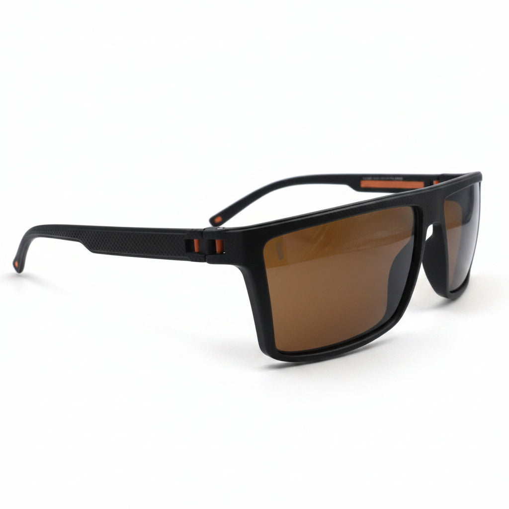 A pair of square-frame sunglasses with a matte black frame and warm brown lenses, displayed on a white surface with two silver studio reflectors in the background.