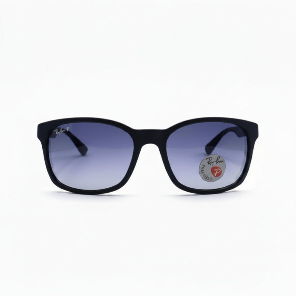 Black square sunglasses with purple gradient lenses, featuring a circular Ray-Ban logo sticker on the right lens, set against a white background with textured black side panels.