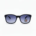 Black square sunglasses with purple gradient lenses, featuring a circular Ray-Ban logo sticker on the right lens, set against a white background with textured black side panels.