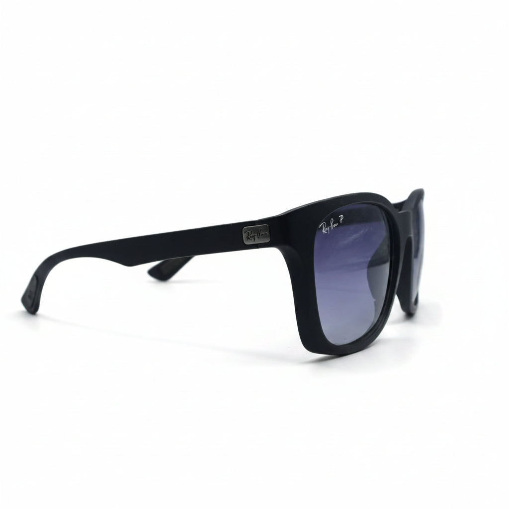 Black square sunglasses with purple gradient lenses, featuring a circular Ray-Ban logo sticker on the right lens, set against a white background with textured black side panels.