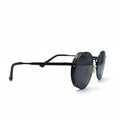 A pair of black round-frame sunglasses with dark lenses, displayed on a white surface with two black fabric panels on either side.