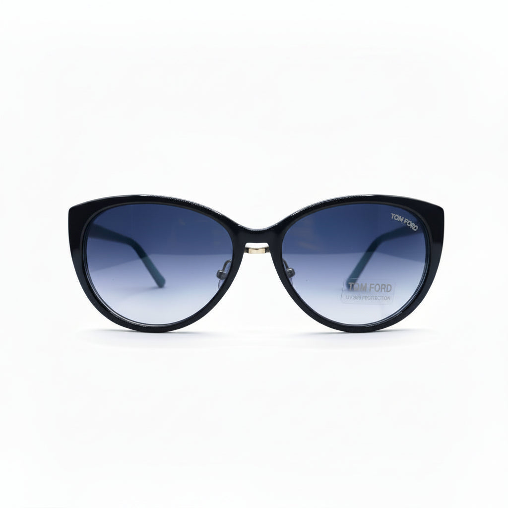 A pair of cat-eye sunglasses with a black frame and blue gradient lenses, displayed on a white surface with textured gray props on either side.