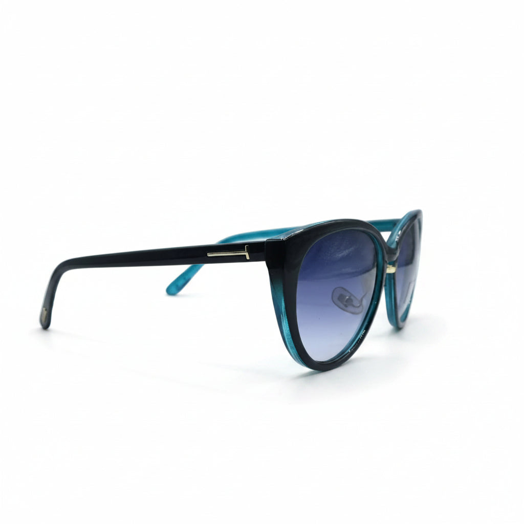 A pair of cat-eye sunglasses with a black acetate frame, vibrant turquoise blue temples, and blue-tinted lenses, displayed on a white surface between two silver studio reflectors.