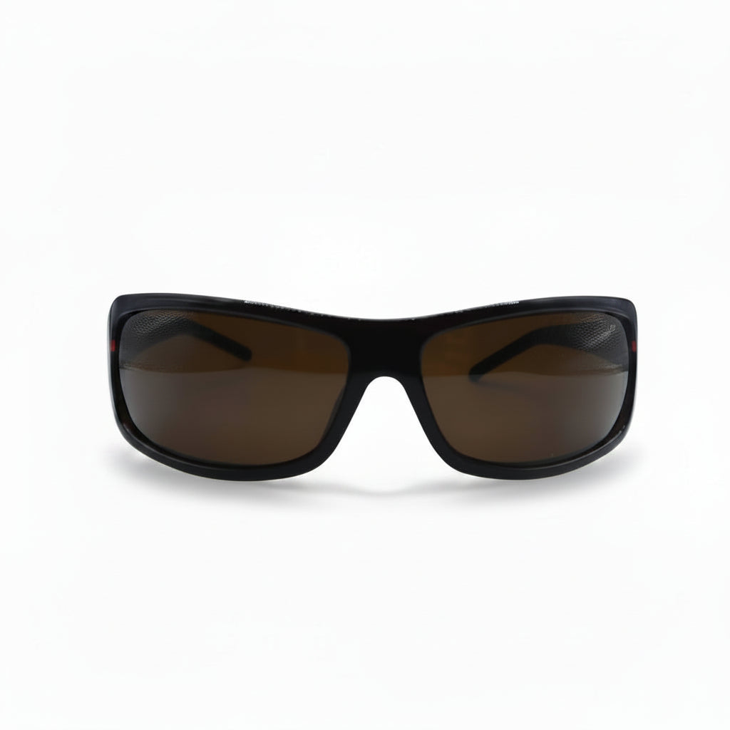 A pair of wrap-around sunglasses with a black frame and brown tinted lenses, displayed on a white surface with two silver reflective stands on either side.