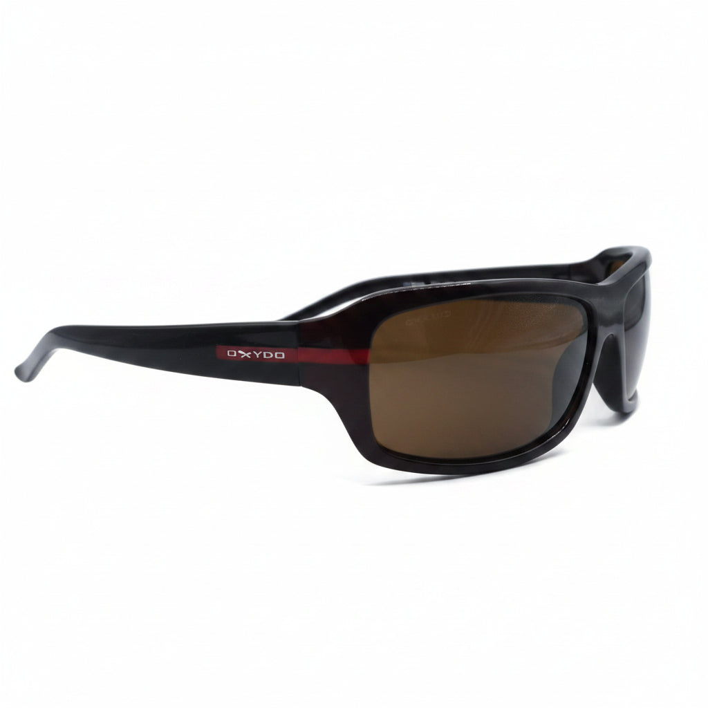 A pair of wrap-around sunglasses with a black frame and brown tinted lenses, displayed on a white surface with two silver reflective stands on either side.