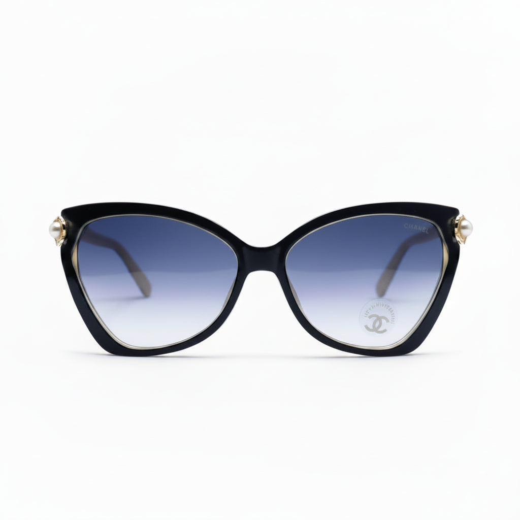 Black cat-eye sunglasses with gradient blue lenses and gold-tone metal accents, displayed on a white surface with a soft shadow.