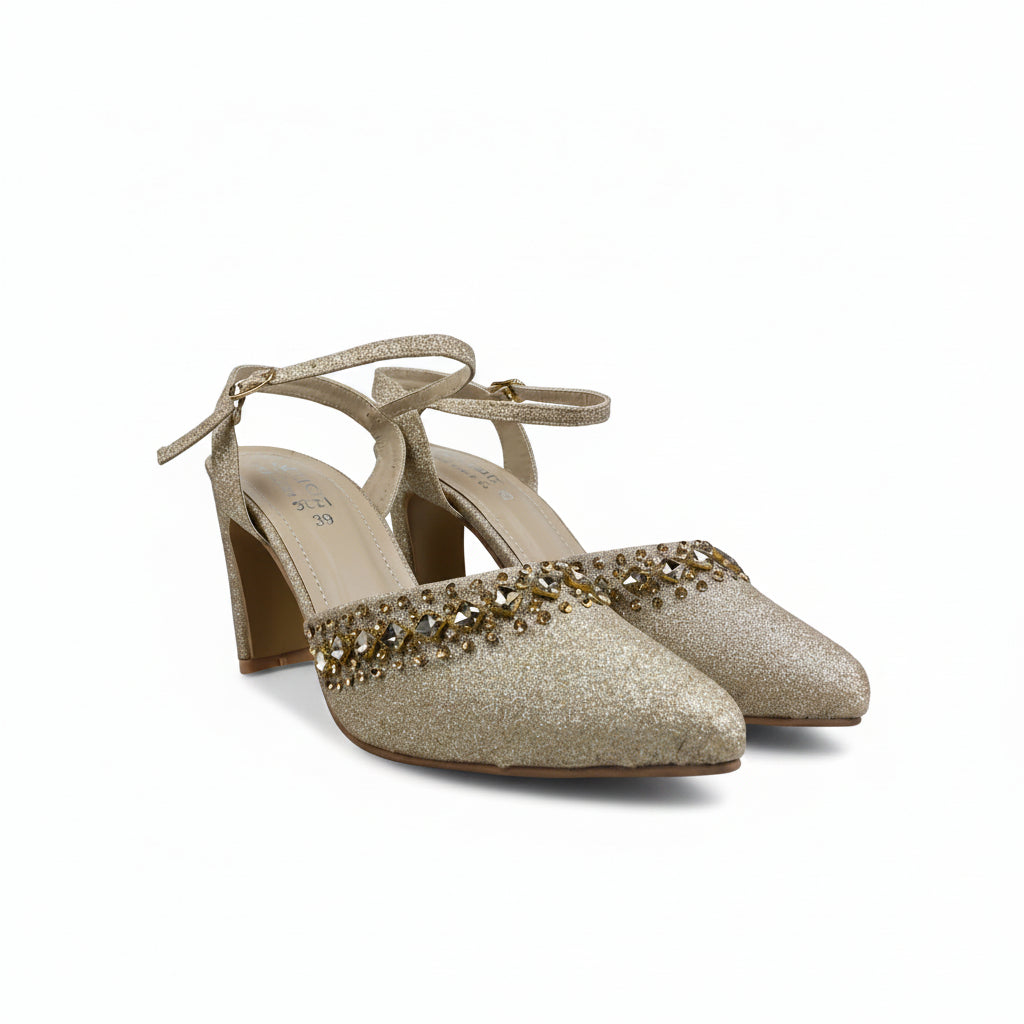 A pair of women's pointed-toe high heels in a glittery champagne gold finish, featuring a decorative band of gold and clear rhinestones across the instep and a slim ankle strap.