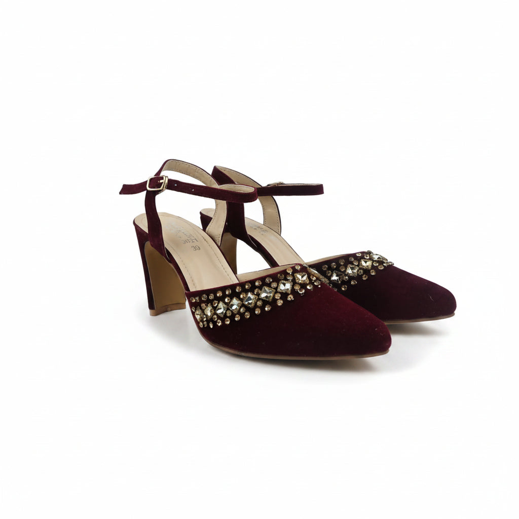 A pair of women's pointed-toe high heels in deep burgundy velvet, featuring a decorative row of gold-tone rhinestones across the toe box and a matching velvet ankle strap with a gold buckle.