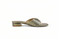 A single metallic gold glitter mule sandal with a low block heel, shown from the side against a light gray fabric backdrop.