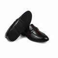 A pair of dark brown leather penny loafers, with one shoe standing upright to show the side and sole, and the other lying on its side to show the toe and vamp. The shoes are photographed on a wrinkled white fabric background.