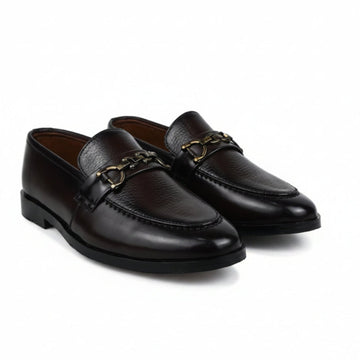 A pair of dark brown leather penny loafers with a gold-tone horsebit detail across the vamp, displayed on a white fabric background.