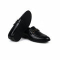 A pair of black leather loafers with a gold-tone chain detail across the vamp, displayed on a white fabric backdrop.