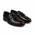 A pair of dark brown leather lace-up loafers with decorative brogue detailing on the toe, displayed on a white fabric background.