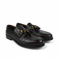 A pair of dark brown crocodile-embossed leather loafers with gold-tone horsebit details and tassel straps, displayed on a white studio background.
