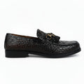 A single dark brown crocodile-embossed loafer with a black tassel and gold-tone hardware, shown in profile against a white studio background.