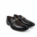 A pair of men's black leather penny loafers with a gold-tone metal horsebit detail across the vamp, displayed on a light gray fabric background.