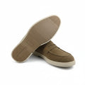 A pair of men's penny loafers in tan suede, with one shoe turned upside down to show the textured tan outsole and the other standing upright to show the side profile and white midsole.