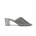 A single silver glitter mule sandal with a block heel, shown from the side against a light gray textured background.