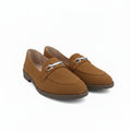 A pair of tan suede penny loafers with silver-tone metal horsebit details on the vamp, displayed on a white studio floor.